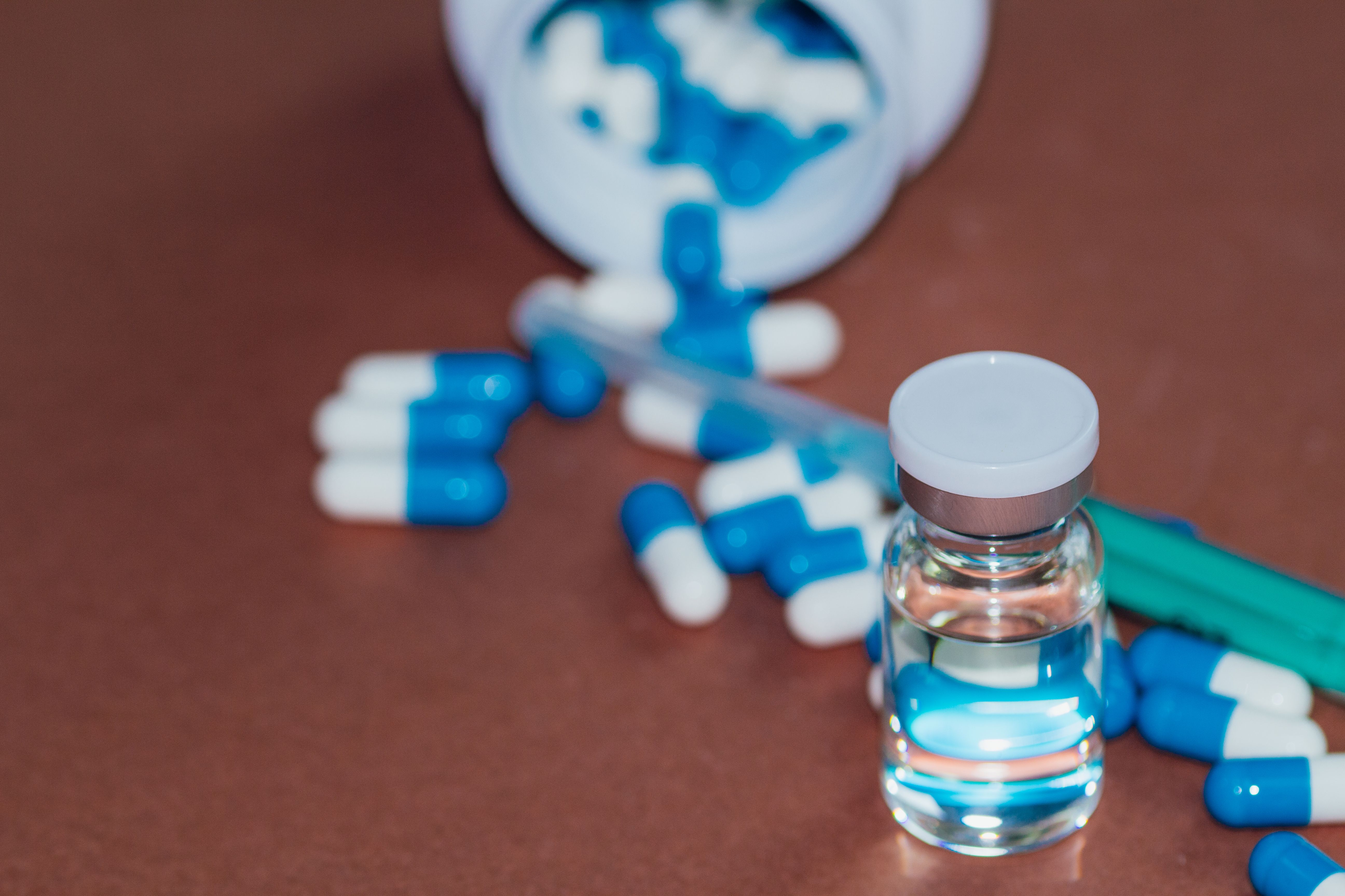 Pills and a vial on a desk