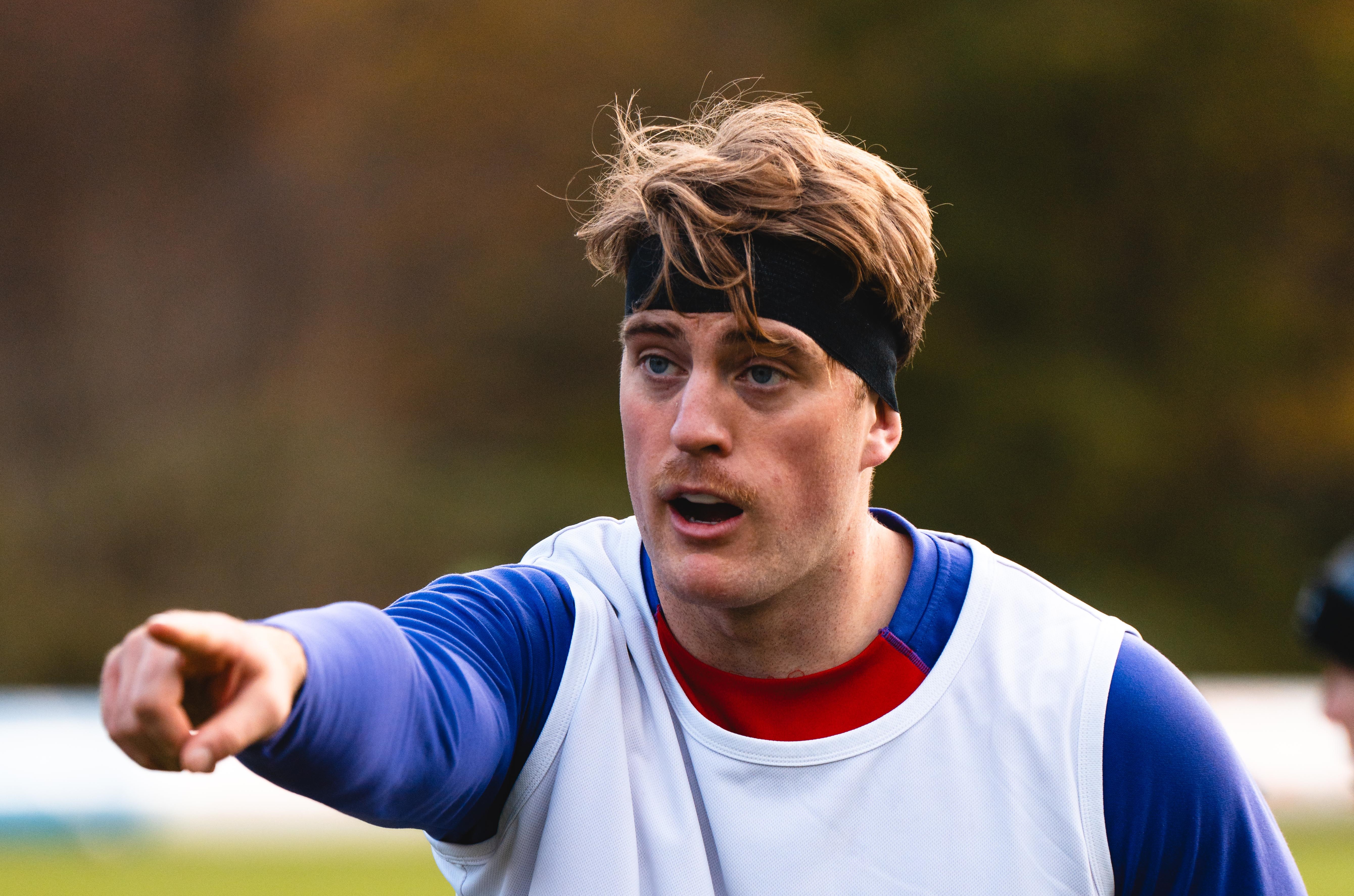 Alex Coles at rugby training pointing at something